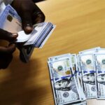 A man exchanges Nigeria’s currency Naira for US dollars in Lagos, Nigeria (Photo by PIUS UTOMI EKPEI – AFP)